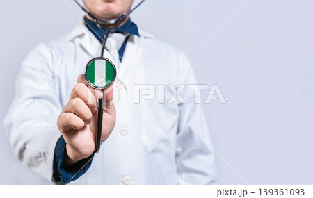 Doctor hands holding stethoscope with Nigeria flag. Nigeria health and care concept Doctor hands holding stethoscope with Nigeria flag. Nigeria health and care concept 139361093