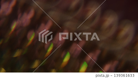 Defocused lens flare. Kaleidoscopic effect. Fractal striping light beam gradient on black. Purple green color abstract background. 139361633