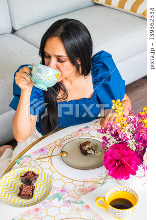 Young brunette woman enjoys eating sweets Young brunette woman enjoys eating sweets 139362338