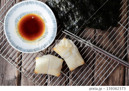 ケーキクーラの上に置いた磯辺焼き用の焼いた餅と醤油と焼き海苔 ケーキクーラの上に置いた磯辺焼き用の焼いた餅と醤油と焼き海苔 139362373