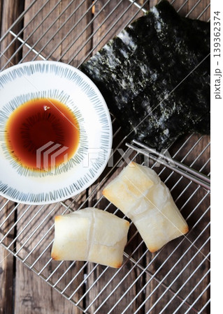 ケーキクーラの上に置いた磯辺焼き用の焼いた餅と醤油と焼き海苔 ケーキクーラの上に置いた磯辺焼き用の焼いた餅と醤油と焼き海苔 139362374