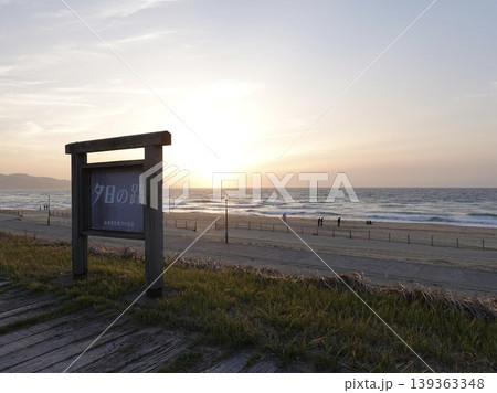 夕日ヶ浦海岸 砂浜沿いの夕日の路の看板越しに見える日没 京都府京丹後市網野町浜詰 夕日ヶ浦海岸 砂浜沿いの夕日の路の看板越しに見える日没 京都府京丹後市網野町浜詰 139363348