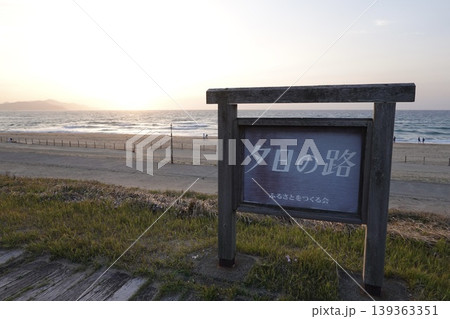 夕日ヶ浦海岸 砂浜沿いの夕日の路の看板越しに見える日没 京都府京丹後市網野町浜詰 夕日ヶ浦海岸 砂浜沿いの夕日の路の看板越しに見える日没 京都府京丹後市網野町浜詰 139363351