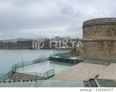 Ancient stone fortress view with cloudy sky and coastline background Ancient stone fortress view with cloudy sky and coastline background 139364257