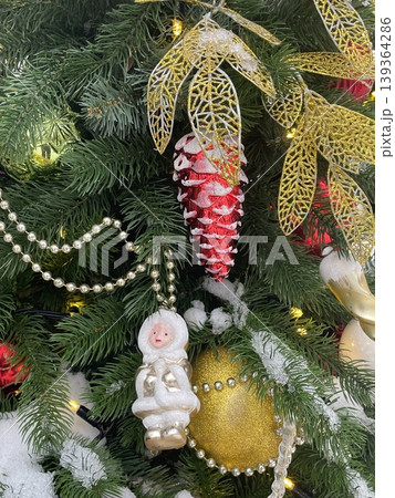 Christmas tree decorated with golden ornaments, snowflakes, and red highlights for festive decor 139364286