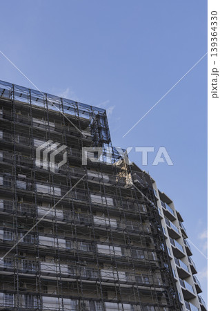 足場とネットで覆われた高層建築 工事中の集合住宅　外壁工事 139364330