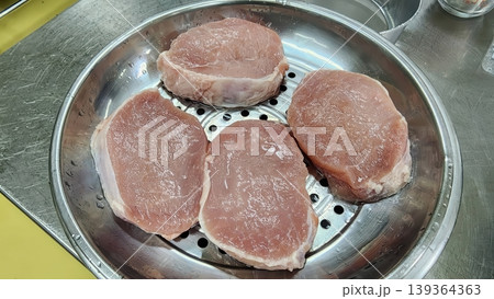 Fresh Raw Pork Loin Steaks in a Metal Steamer Tray in Kitchen Fresh Raw Pork Loin Steaks in a Metal Steamer Tray in Kitchen 139364363