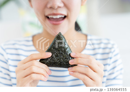 おにぎりを食べる若い女性 139364555
