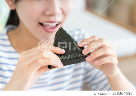 おにぎりを食べる若い女性 139364556