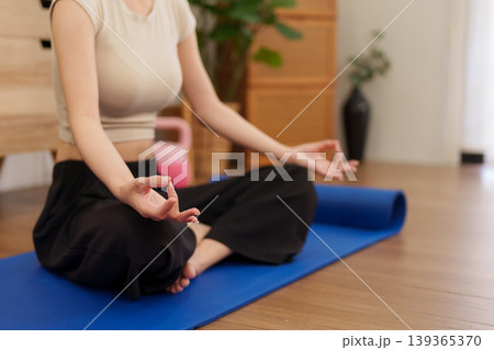 Asian women meditation yoga pose exercise mat home living room floor wellness fitness training health mindfulness relaxation practice lifestyle indoor wooden Asian women meditation yoga pose exercise mat home living room floor wellness fitness training health mindfulness relaxation practice lifestyle indoor wooden 139365370