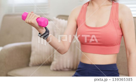 Asian women lifting pink dumbbell weight training exercise workout fitness at home living room wearing sport bra sportswear healthy lifestyle wellness routine Asian women lifting pink dumbbell weight training exercise workout fitness at home living room wearing sport bra sportswear healthy lifestyle wellness routine 139365385