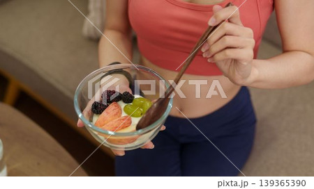healthy eating Caucasian adult women holding glass bowl fresh fruit salad blackberry grape apple snack home kitchen wellness lifestyle nutrition diet balanced 139365390