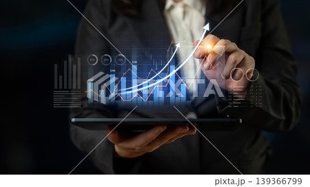 Business professional analyzing financial data on tablet with graph indicators and upward trend lines to depict growth and success in modern workplace Scalp 139366799