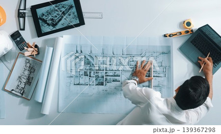 Top view of smart civil engineer drawing and measuring blueprint. Alimentation. 139367298