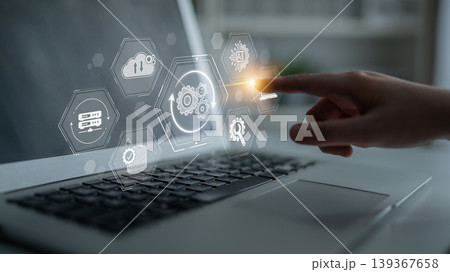 A hand interacts with a digital interface displayed on a laptop, highlighting icons and symbols representing technology, analytics, and cloud computing for modern business solutions. Sigmoid A hand interacts with a digital interface displayed on a laptop, highlighting icons and symbols representing technology, analytics, and cloud computing for modern business solutions. Sigmoid 139367658