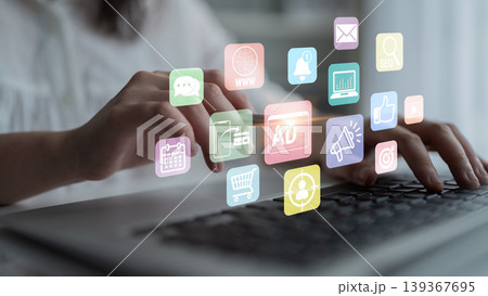 Hands Typing on Laptop Keyboard Surrounded by Colorful Digital Icons Representing Technology, Communication, Marketing, and Business Concepts Fluxor 139367695