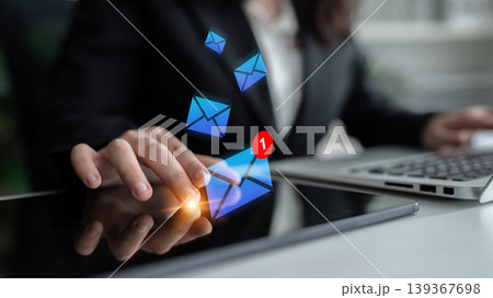 Businessperson Checking Email Notifications on Tablet While Working on Laptop in Modern Office Environment with Digital Mail Icons Floating Gantry 139367698