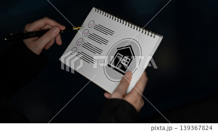 Hands holding a notepad with checklists and a house icon, symbolizing home planning, organization, and project management essentials for housing goals Gantry Hands holding a notepad with checklists and a house icon, symbolizing home planning, organization, and project management essentials for housing goals Gantry 139367824