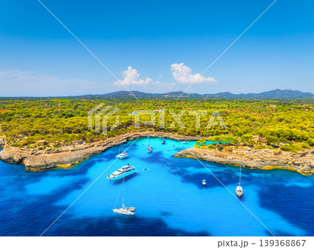 Aerial view of luxury yachts and boats anchored in a turquoise bay on the coast of Mallorca, Spain. 139368867