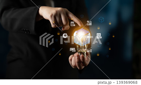 Business innovation concept with a glowing light bulb in hand, showcasing digital icons representing ideas, creativity, and technology for future growth Cyphers. 139369068