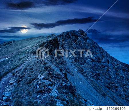 mountain scenery in summer at night. gorgeous mountainous landscape. background with rocky cliffs and grassy hillsides under a cloudy sky. full moon over ridge of mysterious mountains 139369193