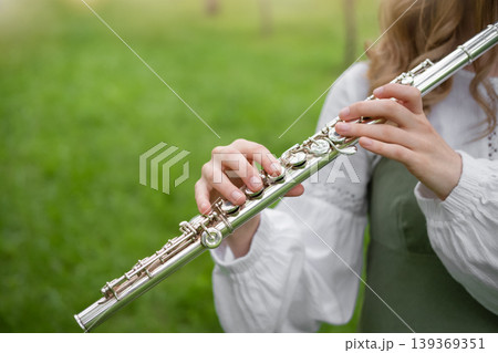 Girl Playing Flute With Park Background. 139369351