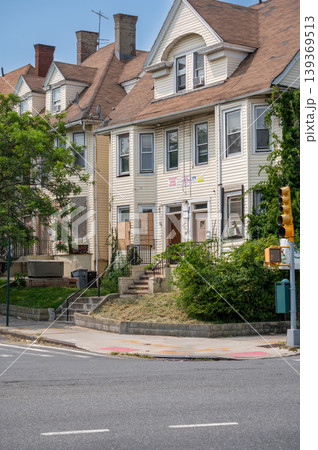New york, usa august 16,2024. Row of aging wooden residential buildings on a quiet new york city street corner, historic urban architecture in summer sunlight 139369513