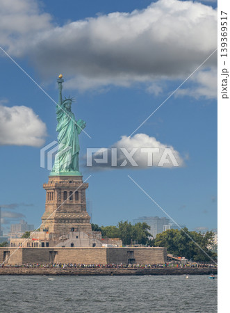 New york, usa august 16,2024. Statue of liberty on liberty island rises against a bright blue sky with scattered white clouds, symbol of freedom and democracy 139369517