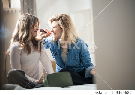 Mother and daughter having fun applying makeup at home Mother and daughter having fun applying makeup at home 139369689