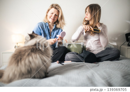 Young women doing morning beauty routine with cat Young women doing morning beauty routine with cat 139369705