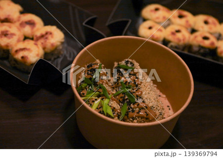 Crispy fried rolls with sauce and sesame seeds in bowl, savory baked sushi on dark table 139369794
