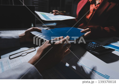 business people or accountant using calculator while working analytical business report on the workplace, accounting concept, Serious and focused financier accountant on paper work inside office, 139370018