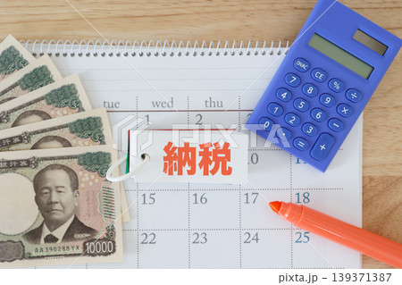 納税期限と支払い。カレンダーと日本円紙幣。電卓とマーカー。赤文字 139371387