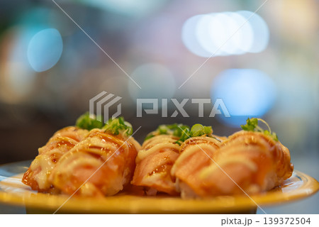 Closeup of salmon sushi topped with creamy sauce and garnish on plate fresh Japanese cuisine appetizer rich flavor bokeh background Closeup of salmon sushi topped with creamy sauce and garnish on plate fresh Japanese cuisine appetizer rich flavor bokeh background 139372504