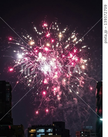 都会の夜空を彩るピンク色の美しい打ち上げ花火 都会の夜空を彩るピンク色の美しい打ち上げ花火 139372709
