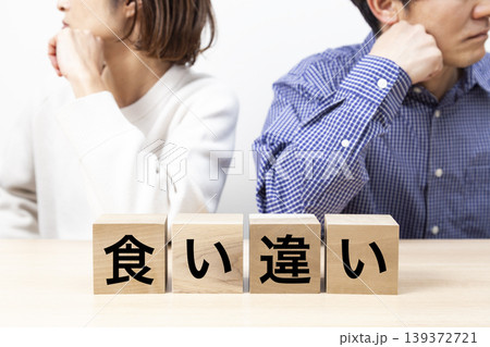「食い違い」と書かれたブロックと喧嘩をする夫婦 「食い違い」と書かれたブロックと喧嘩をする夫婦 139372721
