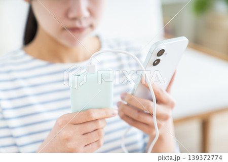 モバイルバッテリーを持つ若い女性 139372774
