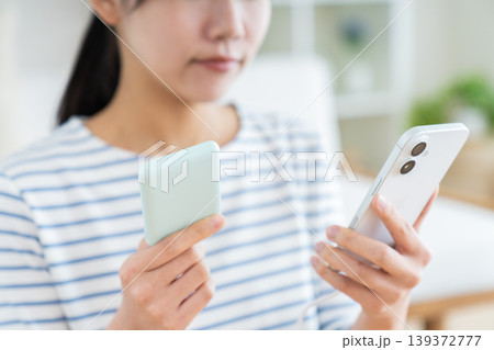 モバイルバッテリーを持つ若い女性 139372777