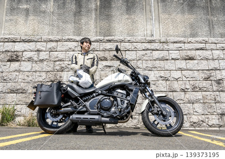 白いクルーザーバイクと立つ男性ライダー 白いクルーザーバイクと立つ男性ライダー 139373195