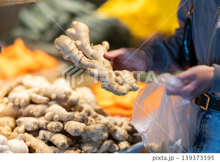 Customer prepares to weigh ginger in a supermarket Customer prepares to weigh ginger in a supermarket 139373595
