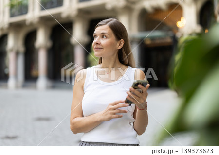 Female pedestrian with phone in summer European capital 139373623
