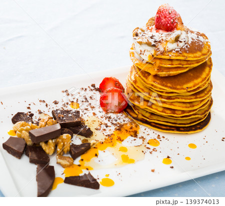 Pancakes served with fruit, honey, chocolate and whipped cream Pancakes served with fruit, honey, chocolate and whipped cream 139374013