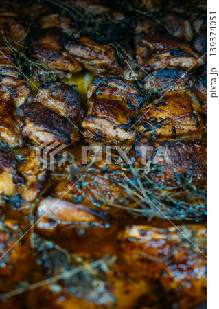 Spicy dish. Barbecue food. Rows of chicken thighs on tray with thyme sprig. Appetizing fat grilled dish for catering restaurant service. 139374051