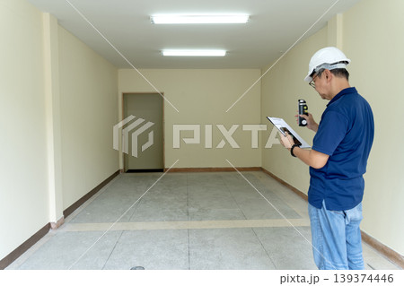 Adult Asian engineer man conducting building inspection empty room using light meter clipboard smartphone construction site quality control work Adult Asian engineer man conducting building inspection empty room using light meter clipboard smartphone construction site quality control work 139374446