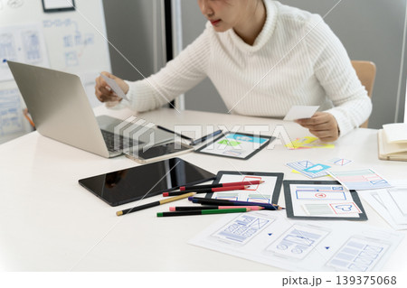 Asian adult woman professional working user experience interface design planning creating software application mockup office 139375068