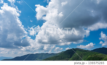 真夏の青空に流れるたくさんの白い雲と、緑に包まれた山々 真夏の青空に流れるたくさんの白い雲と、緑に包まれた山々 139375265