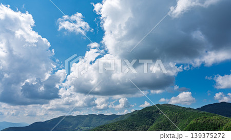 真夏の青空に流れるたくさんの白い雲と、緑に包まれた山々 真夏の青空に流れるたくさんの白い雲と、緑に包まれた山々 139375272