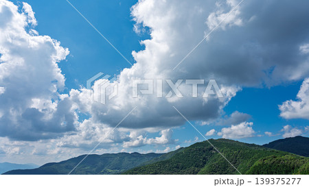 真夏の青空に流れるたくさんの白い雲と、緑に包まれた山々 真夏の青空に流れるたくさんの白い雲と、緑に包まれた山々 139375277