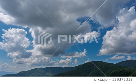 真夏の青空に流れるたくさんの白い雲と、緑に包まれた山々 真夏の青空に流れるたくさんの白い雲と、緑に包まれた山々 139375318