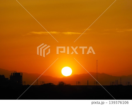 オレンジ色に染まる夕焼け空と関東山地に沈みゆく太陽 オレンジ色に染まる夕焼け空と関東山地に沈みゆく太陽 139376106
